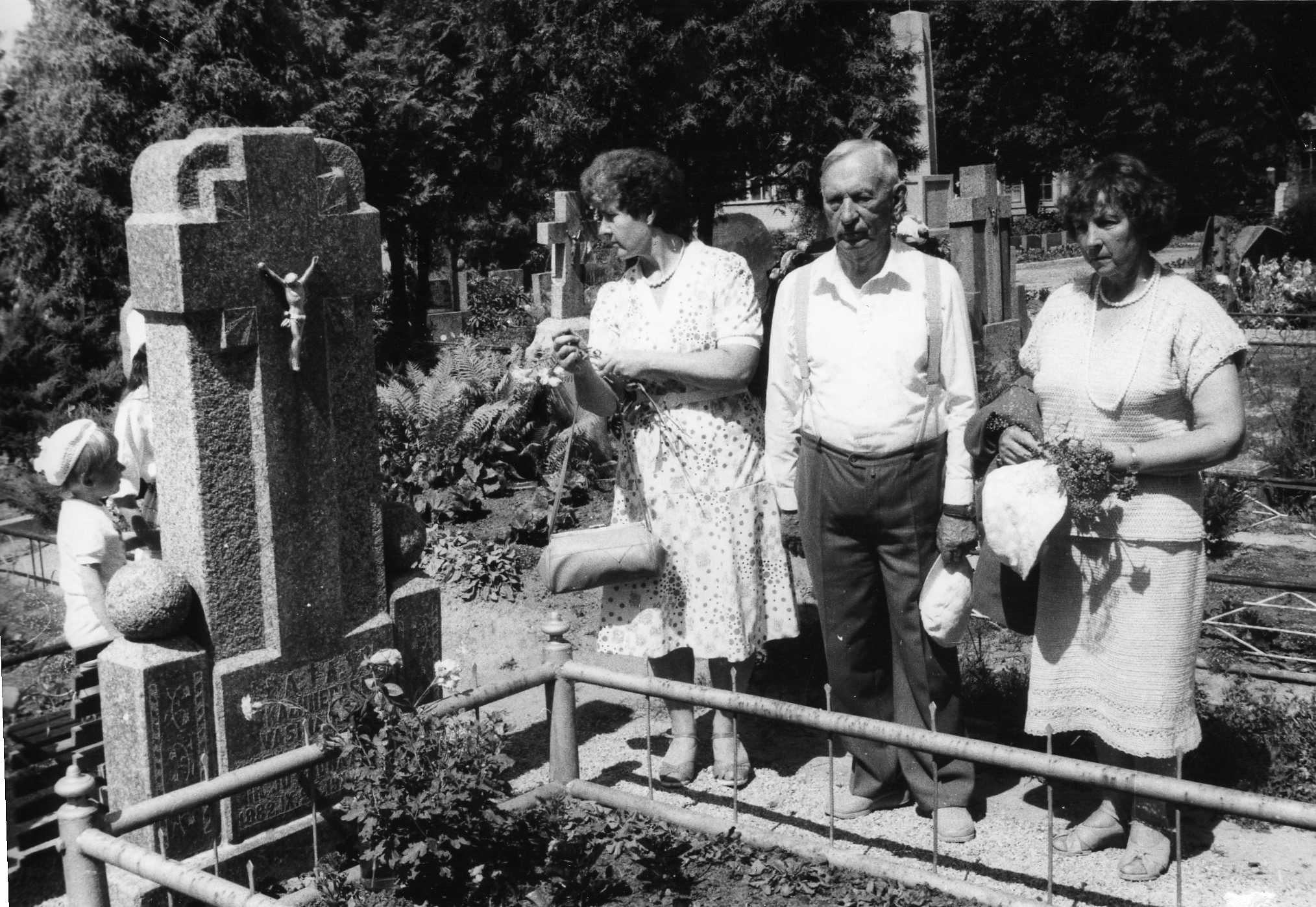 Vasinauskų kapas Pasvalio miesto kapinėse, Stoties g. Prie kapo stovi profesorius, agronomas Petras Vasinauskas su dukterimi Ona Laimute Tindžiuliene (Vasinauskaite) (pirma iš dešinės). 1989 m. 