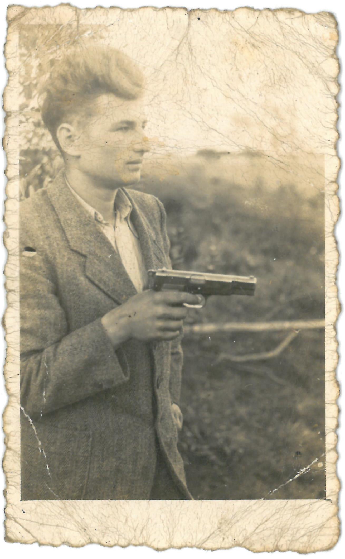 Neatpažintas ginkluotas vyras. Dešinėje rankoje laiko pistoletą „TT-33“. 1948 m. 