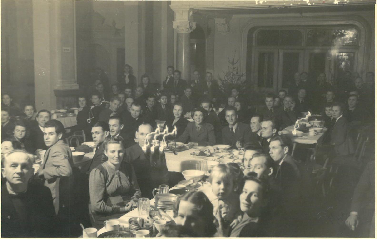 Šv. Kūčių vakarienė DP stovykloje. Vokietija. Kitoje fotografijos pusėje yra užrašas: „Bendra Kūčių / vakarienė / Tremtį 1947 m.“ 