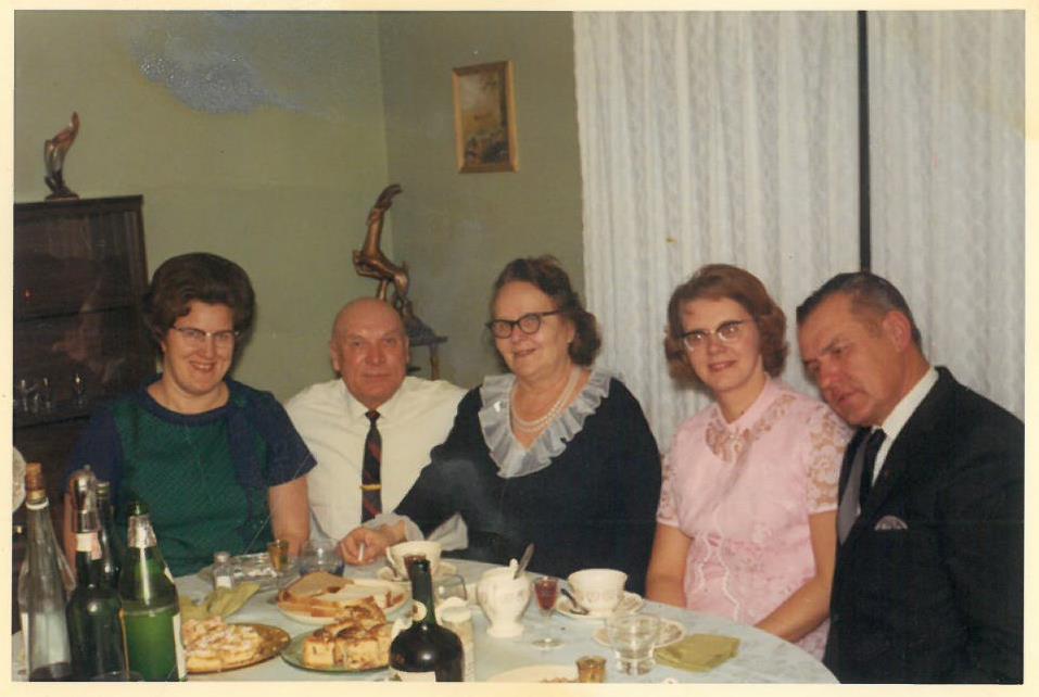 Kazys Balčiūnas (antras iš kairės) prie vaišių stalo. Lemontas, Čikagos priemiestis, JAV.  Kitoje fotografijos pusėje yra užrašas: „Dr. Laimos Pocienės / vizitas pas mane / Lemontas 2-69.“