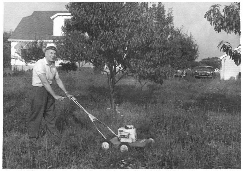 Kazys Balčiūnas savo namų kieme pjauna žolę. Lemontas, Čikagos priemiestis, JAV