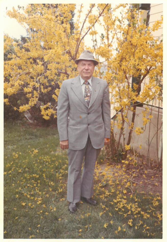 Kazys Balčiūnas savo namuose, stovi šalia tarpinės forsitijos krūmo. Lemontas, Čikagos priemiestis, JAV