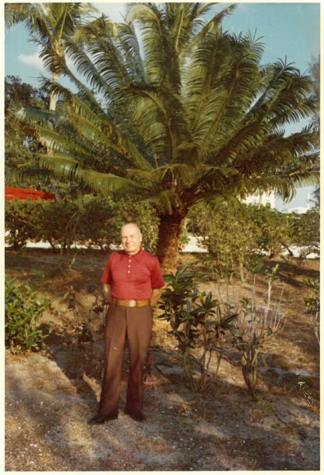 Kazys Balčiūnas pozuoja šalia augančio palmės medžio. JAV