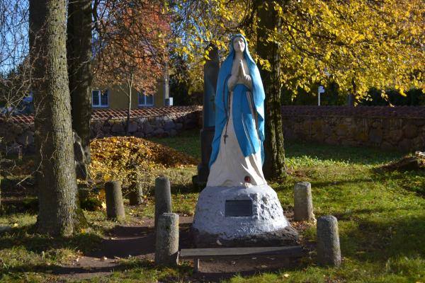 Daujėnų Švč. Jėzaus Vardo bažnyčios šventoriuje stovi Švč. Mergelės Marijos skulptūra. Nuotrauka iš Pasvalio Mariaus Katiliškio viešosios bibliotekos Krašto kultūros dokumentavimo centro fondų, 2015