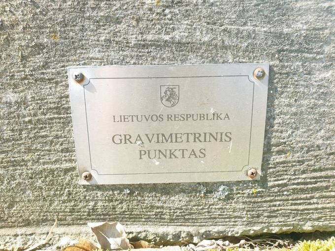 Prie Skrebotiškio Švč. Jėzaus Širdies bažnyčios galinių durų laiptelių pritvirtinta metalinė lentelė su įrašu: „Lietuvos Respublika. Gravimetrinis punktas“. Tomos Mikalajūnaitės nuotrauka, 2020