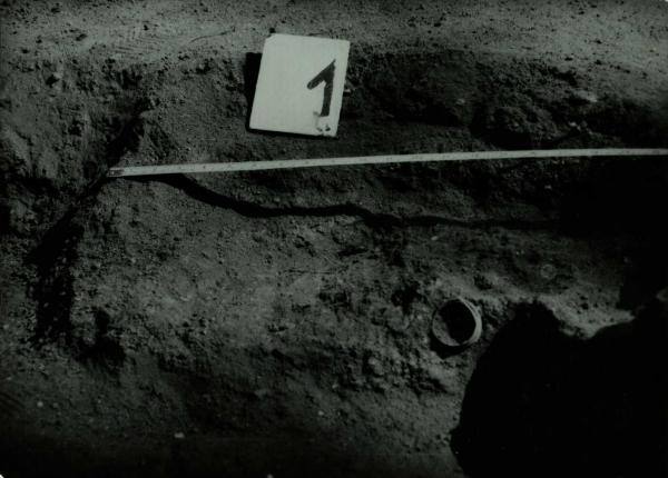 Norelių kapinynas. Perkasa I. Kapas nr. 1 iš šiaurės vakarų pusės atidengimo metu: [nuotrauka] // Tebelškis P. Norelių kapinynas: IP 2399/A (Pasvalio r.) 1997 m. žvalgomųjų archeologinių tyrimų ataskaita. – Vilnius, 1997.