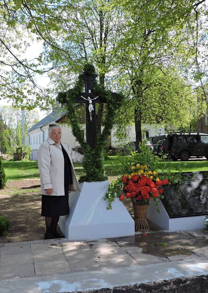 Bronė Čekanauskienė prie atstatyto kryžiaus centrinėje Pumpėnų aikštėje. Gražvydo Balčiūnaičio nuotrauka, 2018