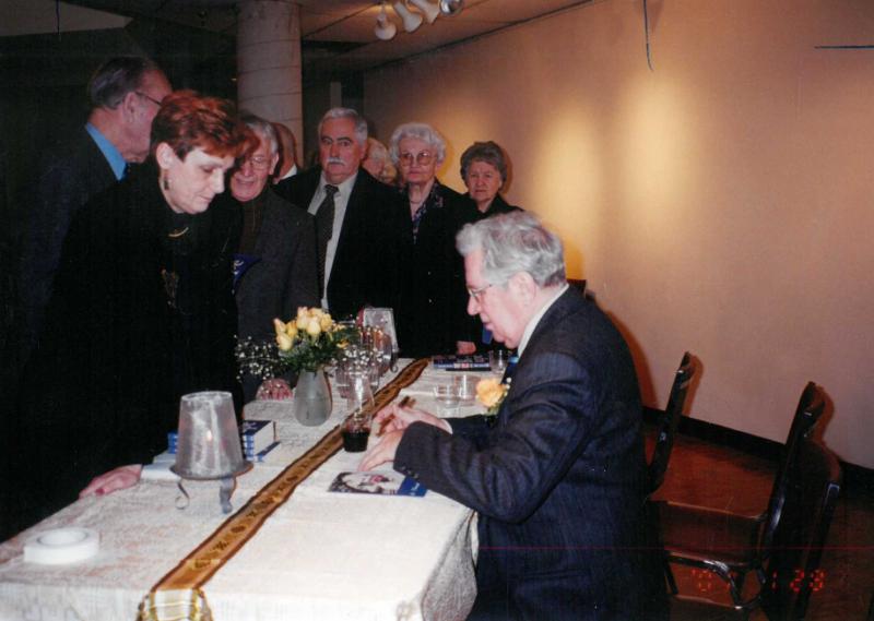 Rašytojas, savaitraščio „Tėviškės Žiburiai“ redaktorius Česlovas Senkevičius dalija autografus po savo knygos „Ketvirtoji upė“ pristatymo Anapilio muziejaus parodų salėje, Mississaugoje (Kanada). 2001 m. sausio 28 d.